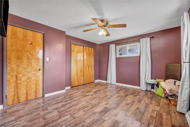 unfurnished bedroom with wood finished floors, baseboards, a closet, and ceiling fan