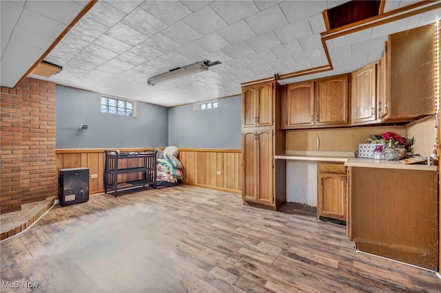 bar with light wood finished floors, a wainscoted wall, and wood walls