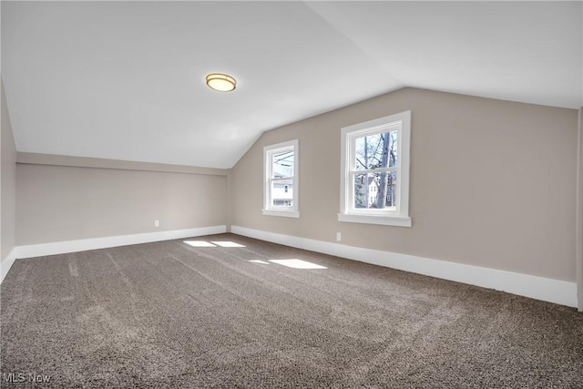 bonus room with carpet floors, baseboards, and vaulted ceiling