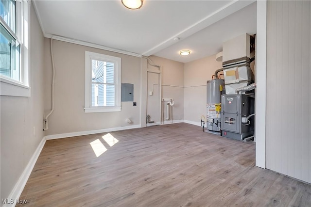 interior space featuring gas water heater, electric panel, wood finished floors, and baseboards