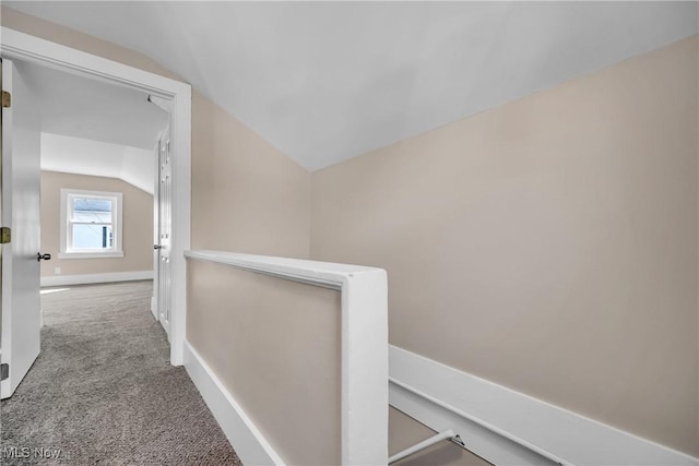 hall with baseboards, carpet floors, lofted ceiling, and an upstairs landing