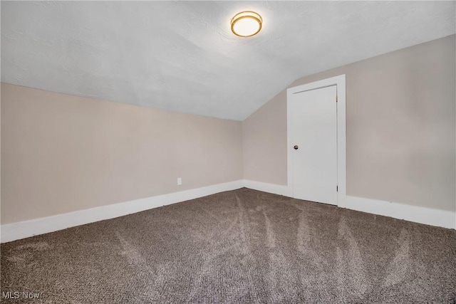 bonus room featuring baseboards, carpet floors, a textured ceiling, and vaulted ceiling