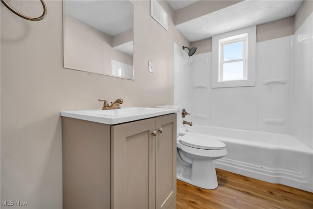 full bath with visible vents, tub / shower combination, toilet, wood finished floors, and vanity