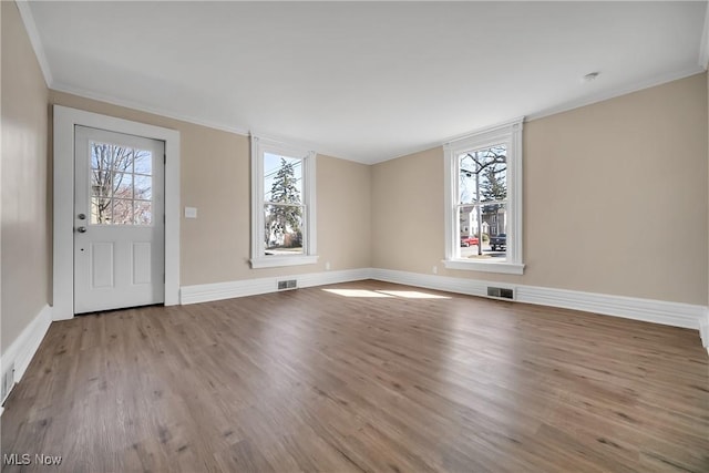 foyer entrance featuring wood finished floors, a healthy amount of sunlight, and visible vents