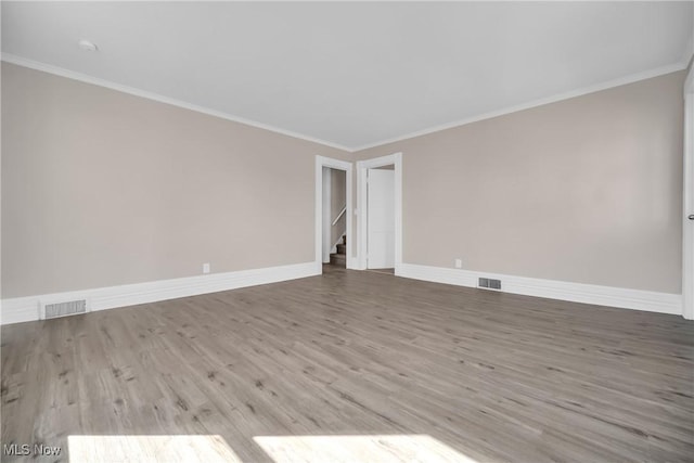 unfurnished room featuring visible vents, baseboards, and ornamental molding