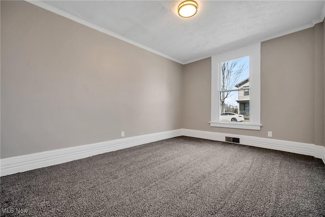 carpeted empty room featuring visible vents, baseboards, and crown molding