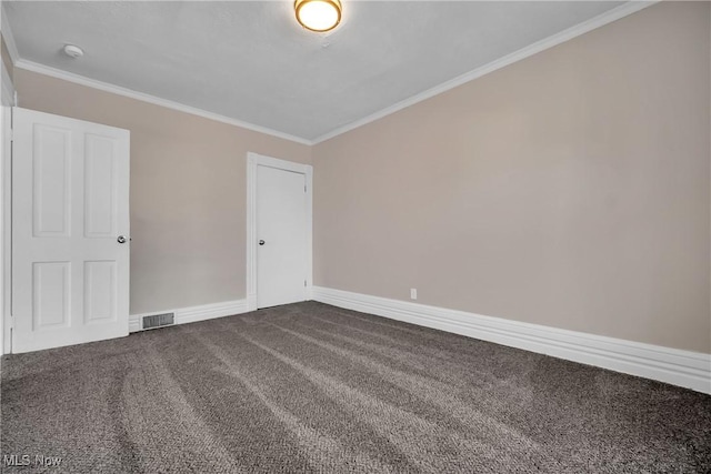 unfurnished room with visible vents, dark carpet, baseboards, and ornamental molding