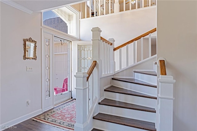 entrance foyer featuring stairs, baseboards, and wood finished floors