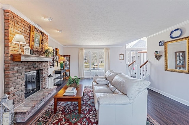 living room featuring a textured ceiling, wood finished floors, a fireplace, crown molding, and baseboards