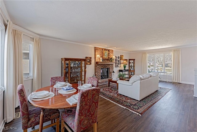 dining room featuring ornamental molding, a fireplace, dark wood-style flooring, and a textured ceiling