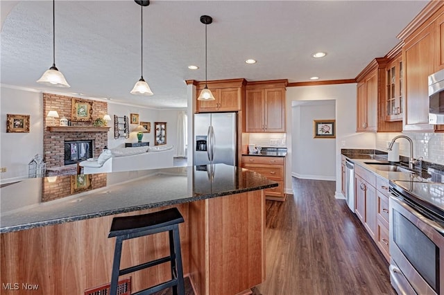 kitchen with a sink, crown molding, glass insert cabinets, and stainless steel appliances