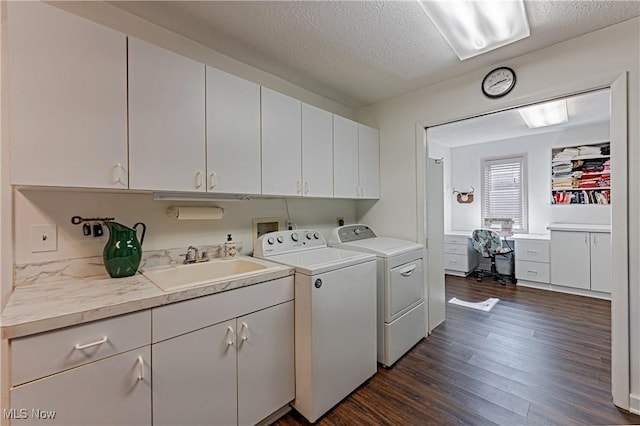 clothes washing area with dark wood-style flooring, separate washer and dryer, cabinet space, a textured ceiling, and a sink