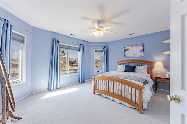 carpeted bedroom with visible vents, baseboards, and a ceiling fan