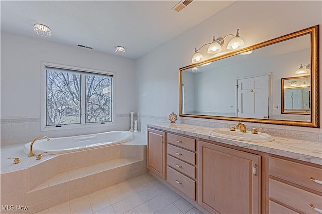 bathroom with tile patterned floors, visible vents, a bath, and vanity