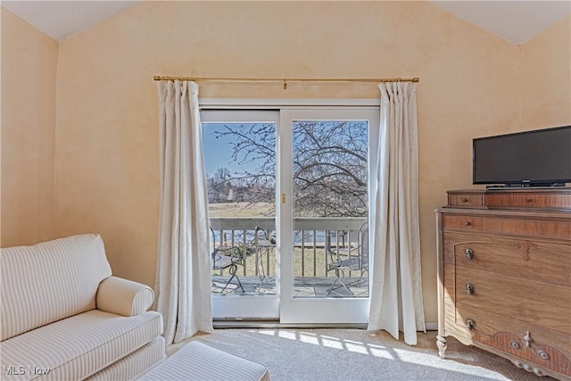 sitting room with carpet flooring and vaulted ceiling