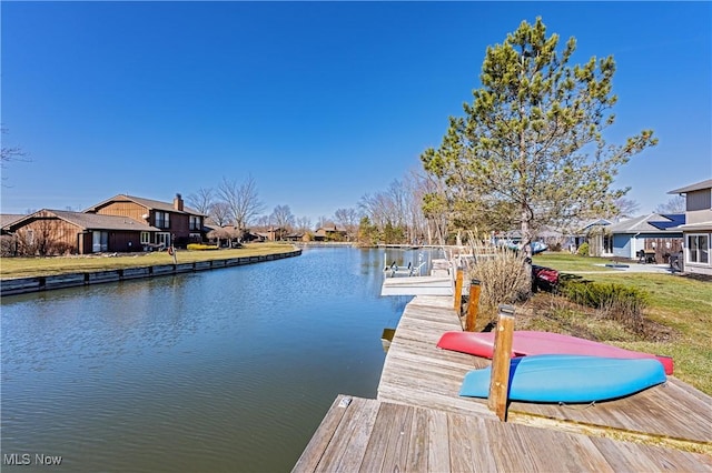 view of dock with a lawn, a water view, and a residential view