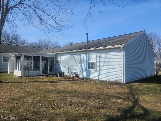 back of house featuring central air condition unit, a yard, and a sunroom