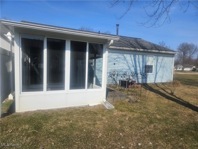 view of home's exterior featuring a lawn and a sunroom