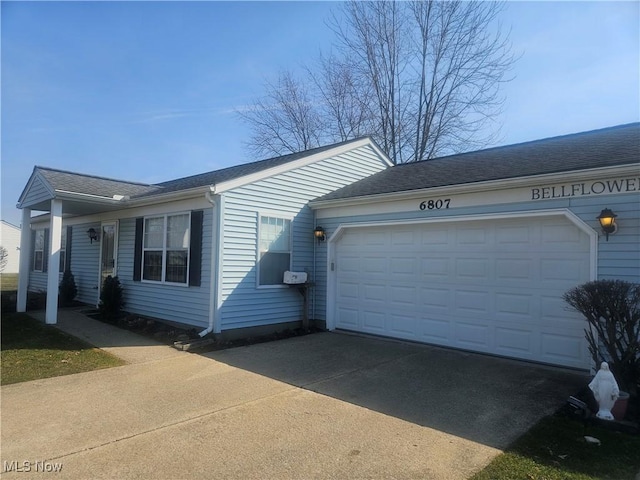 view of front of house featuring concrete driveway, a garage, and a shingled roof