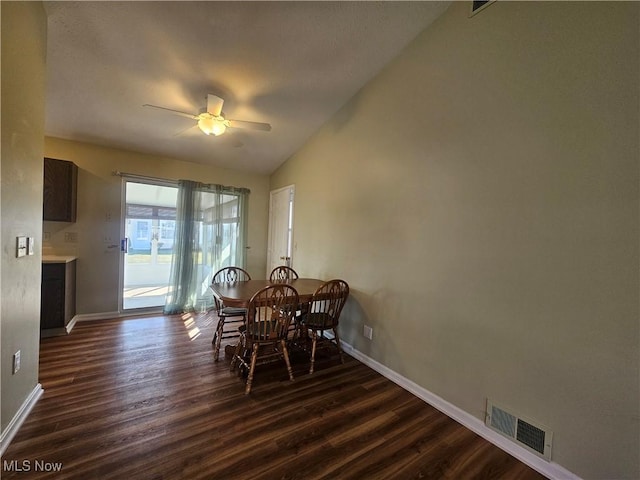 dining room with a ceiling fan, visible vents, baseboards, lofted ceiling, and dark wood-style flooring