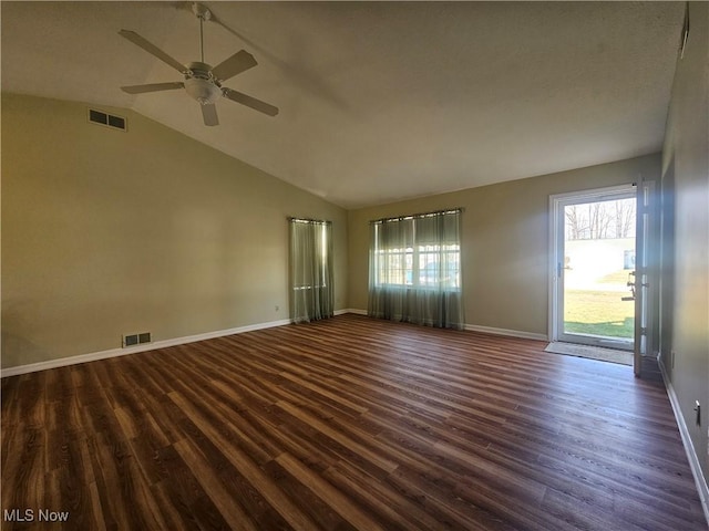 unfurnished room with a wealth of natural light, visible vents, and dark wood-style flooring