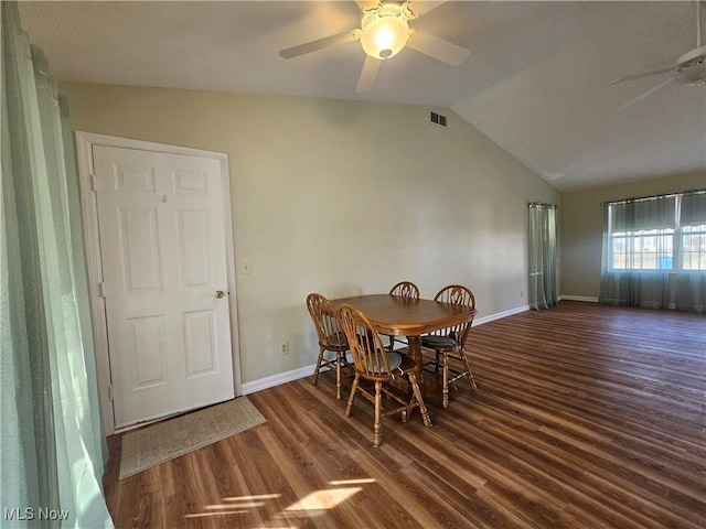 dining space featuring visible vents, baseboards, lofted ceiling, wood finished floors, and a ceiling fan