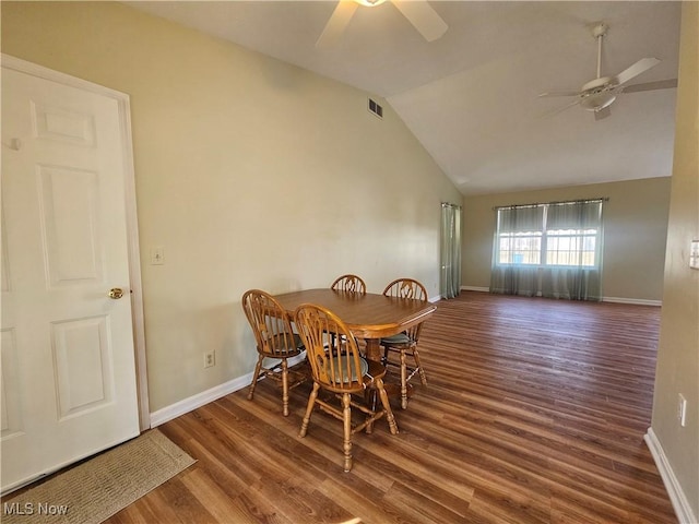 dining room with visible vents, wood finished floors, baseboards, ceiling fan, and vaulted ceiling