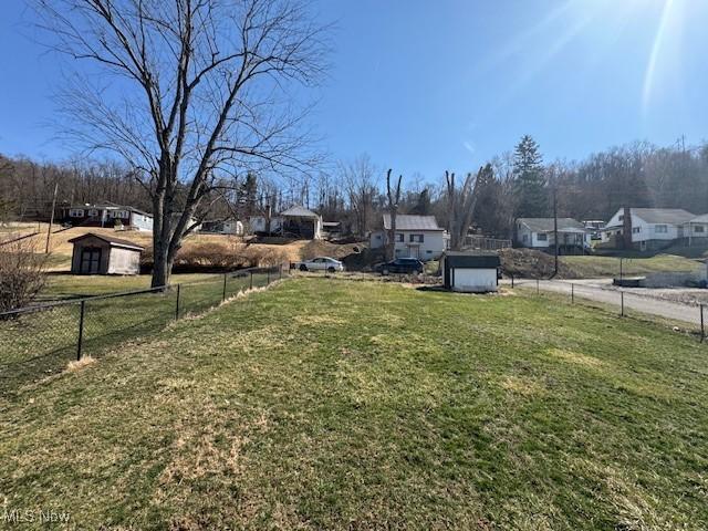 view of yard with a storage unit, an outdoor structure, and fence