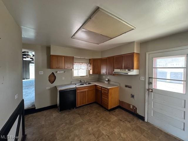 kitchen featuring extractor fan, light countertops, black dishwasher, brown cabinetry, and a sink