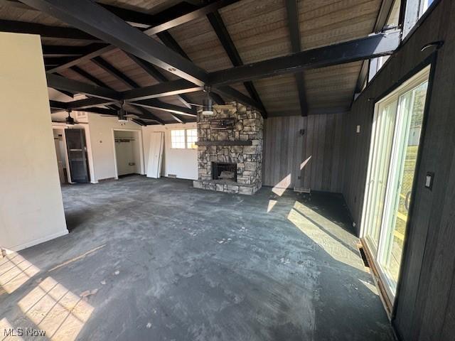 unfurnished living room featuring lofted ceiling, concrete flooring, and a fireplace