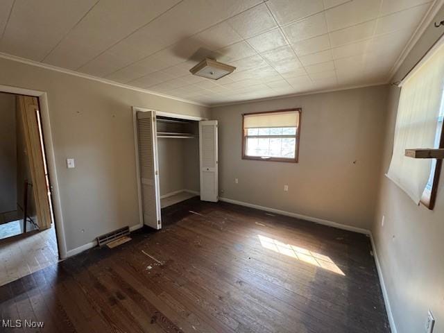 unfurnished bedroom featuring dark wood-style floors, baseboards, and ornamental molding