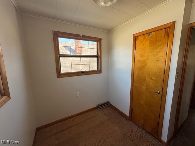 unfurnished bedroom with crown molding, visible vents, and baseboards