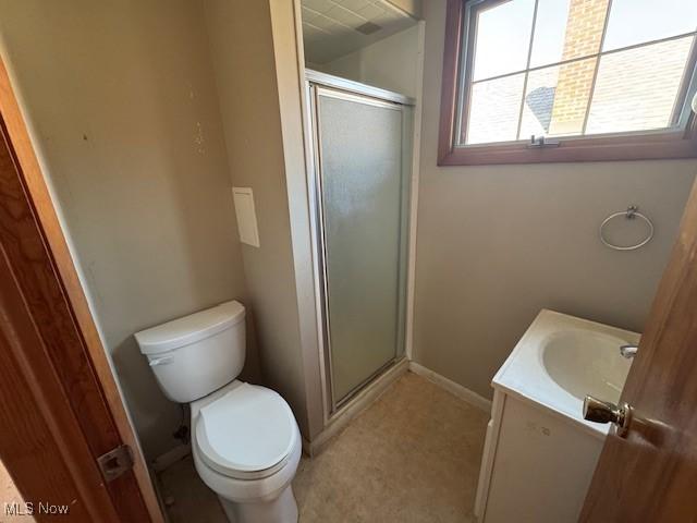 full bathroom featuring baseboards, toilet, a stall shower, and vanity