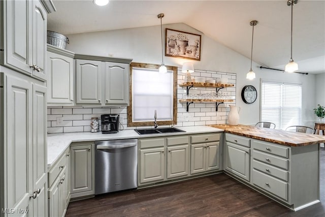 kitchen with lofted ceiling, gray cabinets, a peninsula, stainless steel dishwasher, and a sink