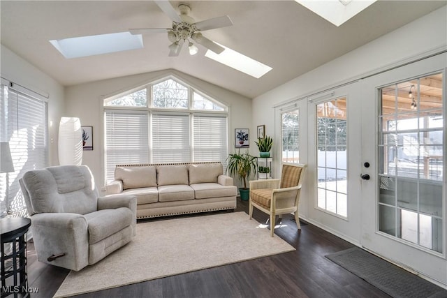 living room with dark wood-style floors, vaulted ceiling with skylight, and ceiling fan