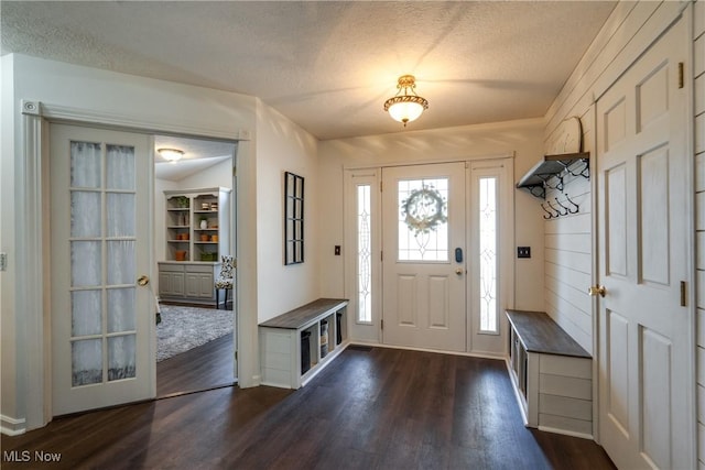 entrance foyer with dark wood-type flooring and a textured ceiling