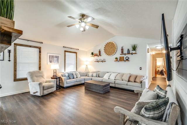 living area with dark wood finished floors, lofted ceiling, and a ceiling fan