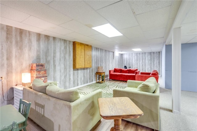 living room with a paneled ceiling and carpet