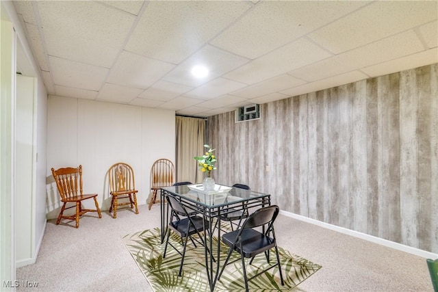 dining area featuring a drop ceiling and carpet