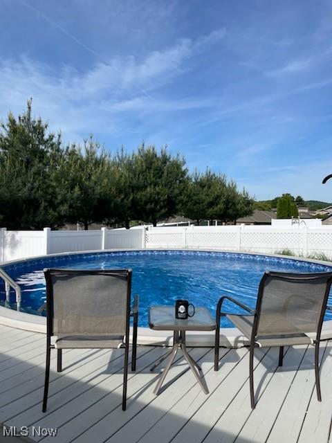 view of swimming pool featuring a fenced backyard, a fenced in pool, and a wooden deck