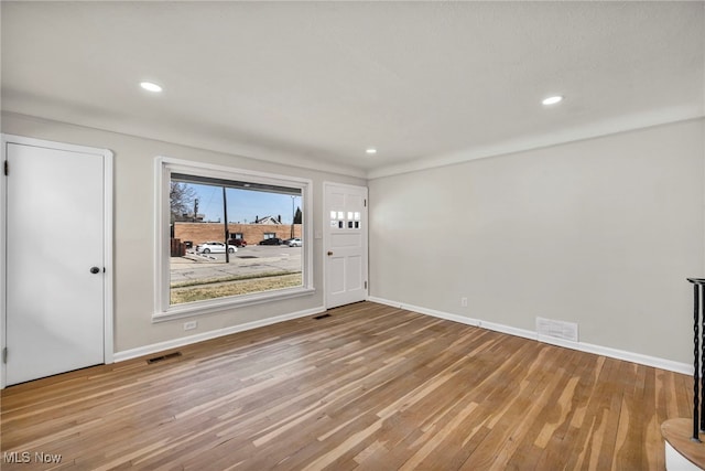 interior space with wood finished floors, visible vents, and baseboards