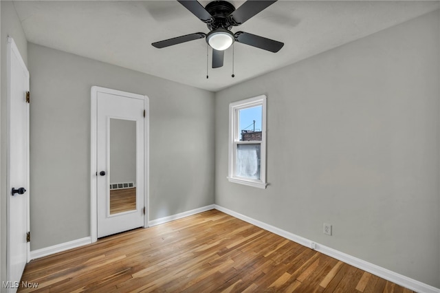 unfurnished bedroom featuring a ceiling fan, wood finished floors, and baseboards