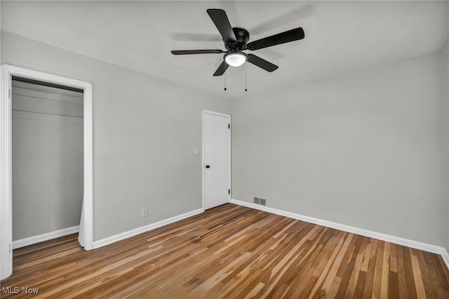 unfurnished bedroom featuring visible vents, baseboards, and hardwood / wood-style flooring