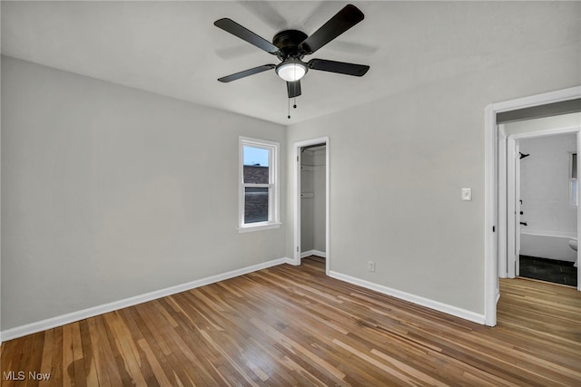 empty room with ceiling fan, baseboards, and wood finished floors