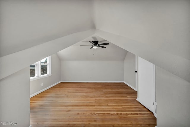 bonus room with vaulted ceiling, baseboards, light wood-type flooring, and ceiling fan