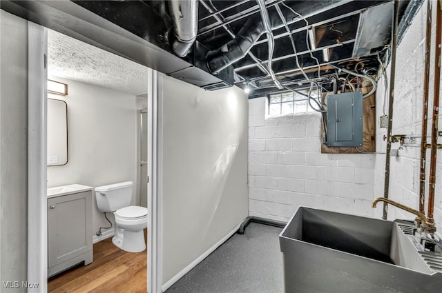 full bathroom featuring electric panel, toilet, vanity, and baseboards