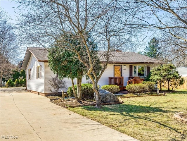 ranch-style house featuring roof with shingles, concrete driveway, and a front lawn