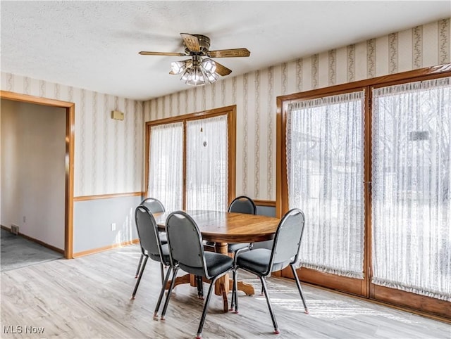 dining area featuring wallpapered walls, baseboards, and ceiling fan