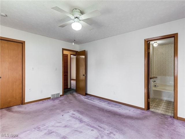 unfurnished bedroom featuring visible vents, carpet floors, and a textured ceiling