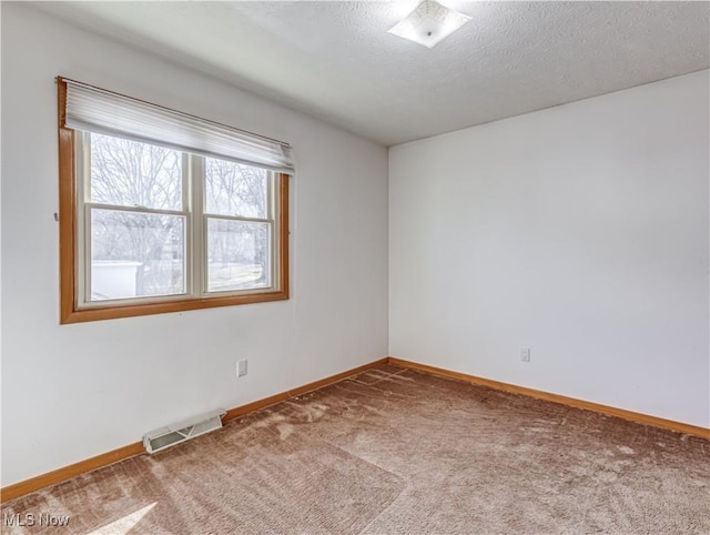 unfurnished room featuring visible vents, a textured ceiling, baseboards, and carpet floors